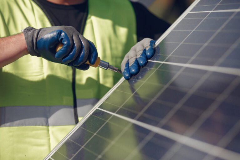 Engineer in a white helmet. Man near solar panel.