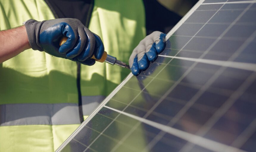 Engineer in a white helmet. Man near solar panel.